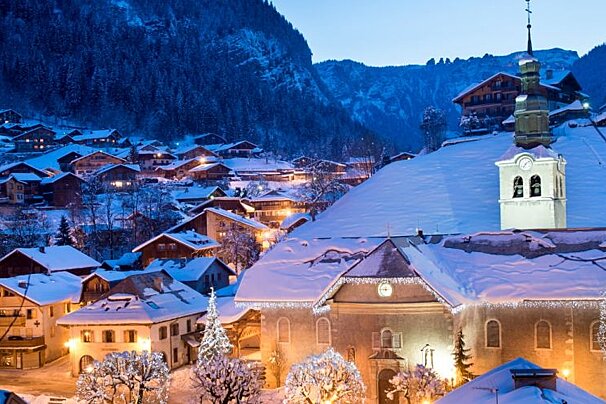 A snowy village with a church in the foreground