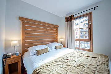 A bedroom with a large bed and a window