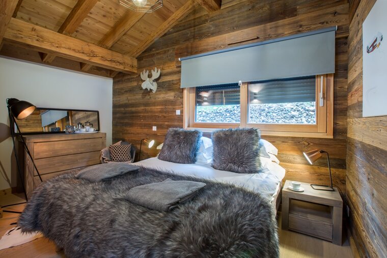 A bedroom with a large bed and a dresser