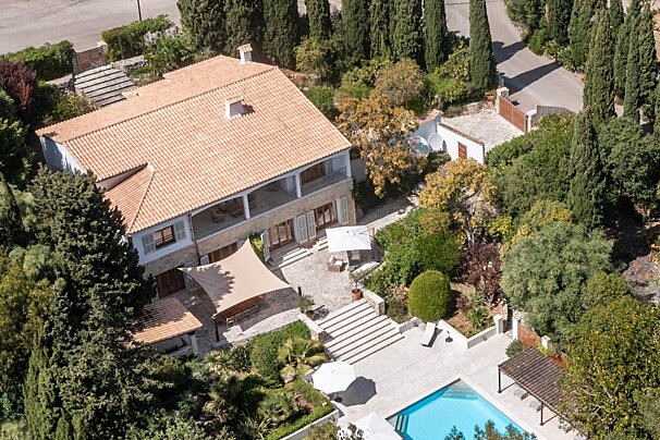 An aerial view of a large house with a swimming pool