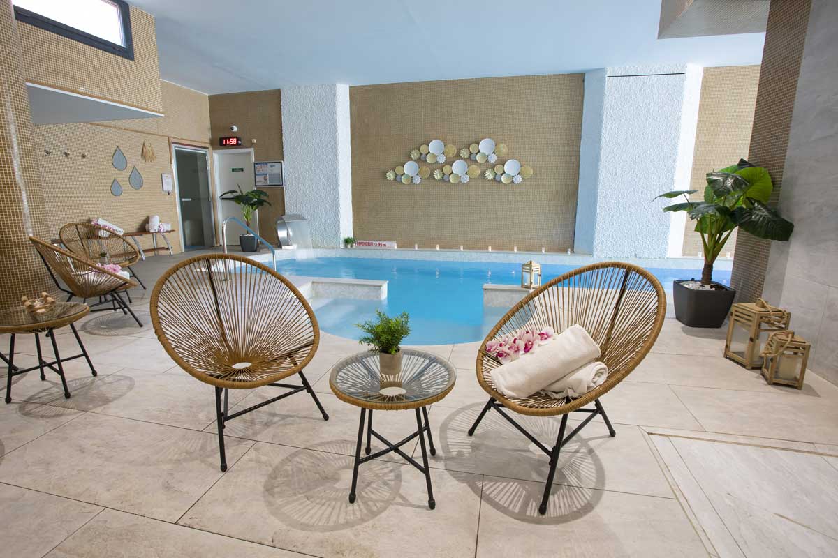 Two chairs and a table in front of a swimming pool