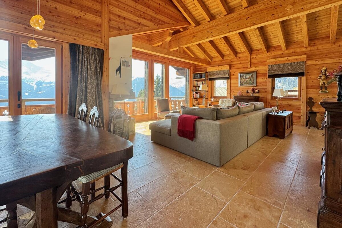 A living room in a log cabin with a couch and a table