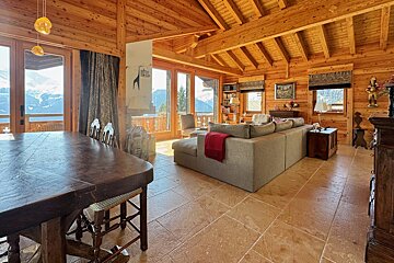 A living room in a log cabin with a couch and a table