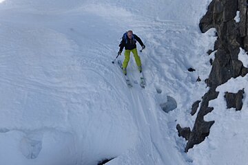 a skier on a steep narrow gorge