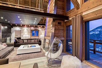 a chalet with large windows & fireplace
