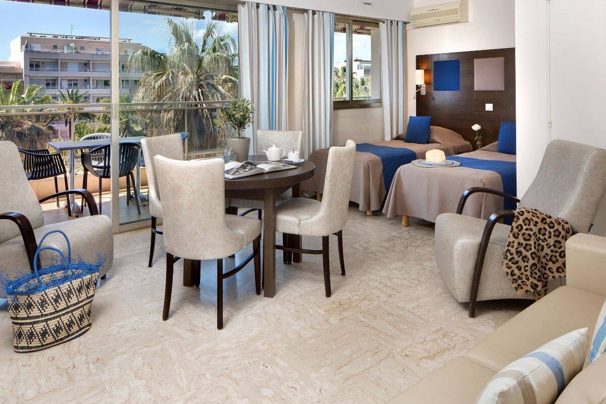 A hotel room with two beds and a table and chairs