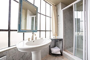 A bathroom with a sink a mirror and a walk in shower