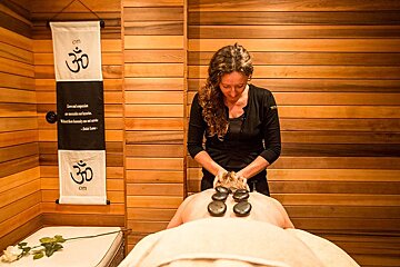 A woman is giving a man a massage in front of a sign that says om