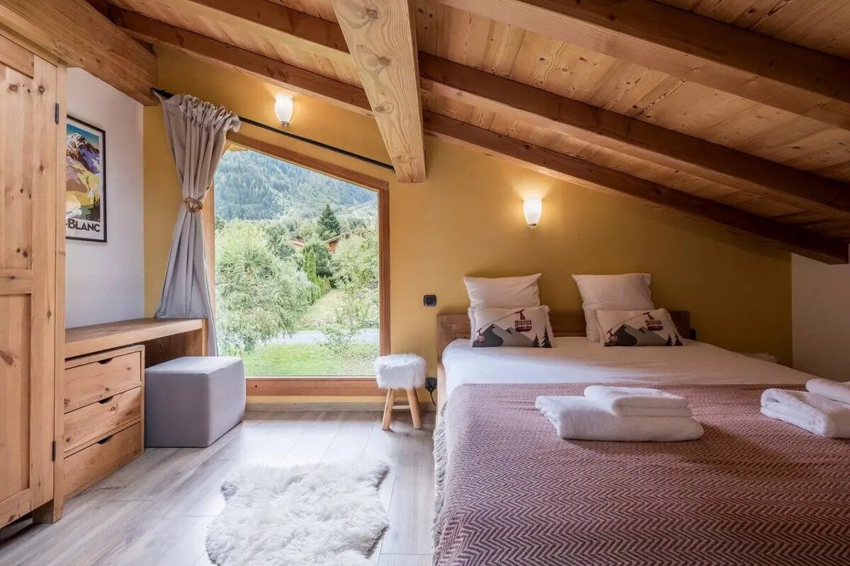 A bedroom with a bed and a picture of mont blanc on the wall