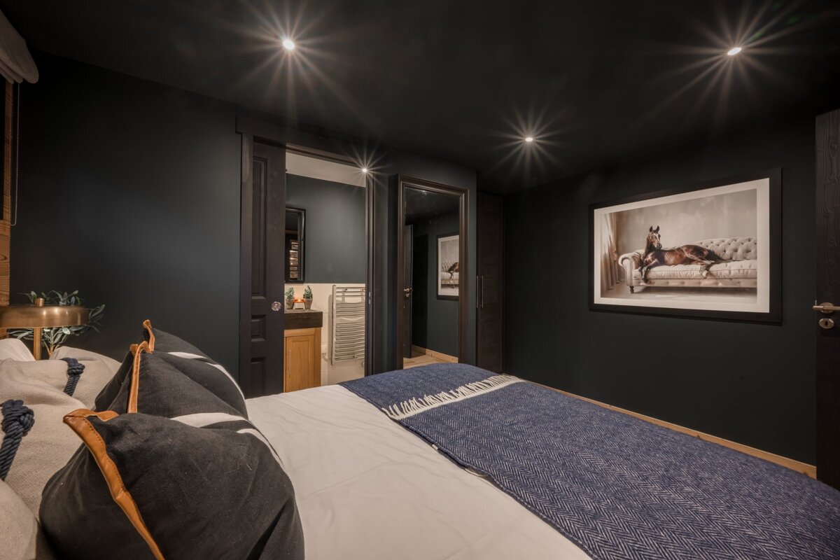 A bedroom with a picture of a horse on a couch