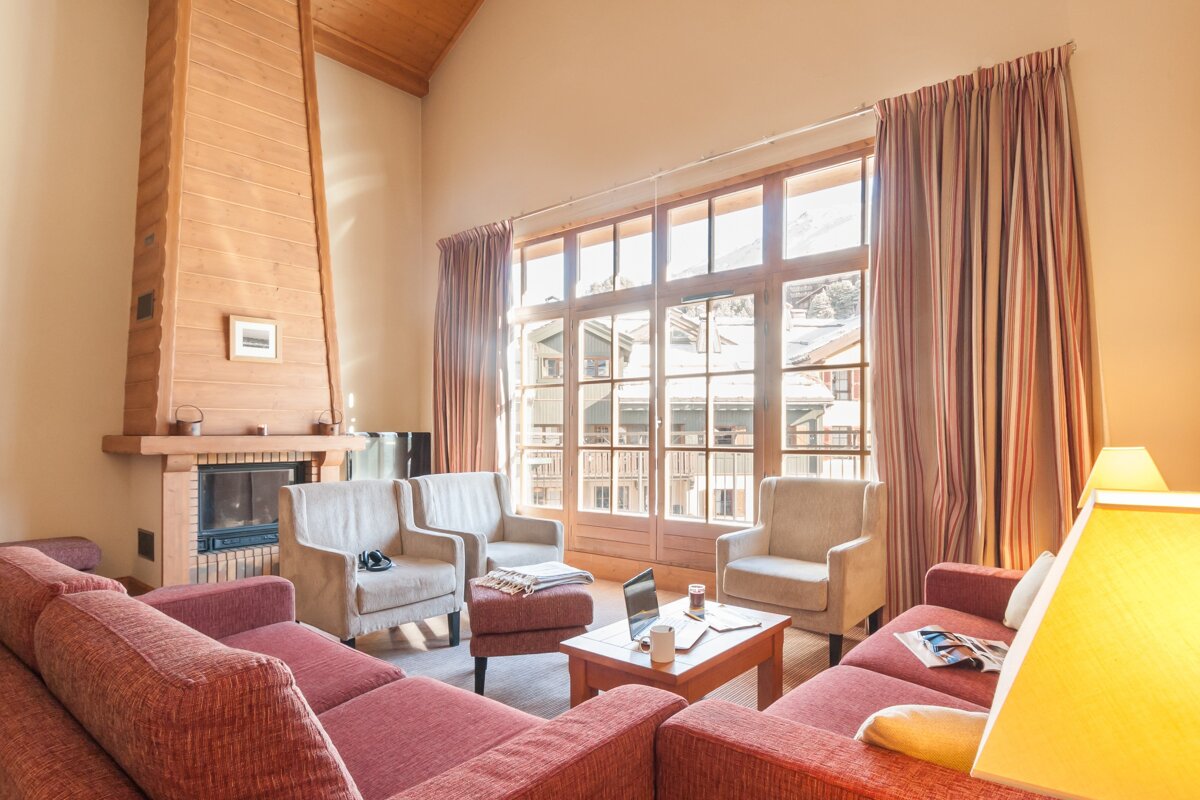 A living room with a couch and chairs and a fireplace