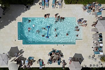 An aerial view of a swimming pool filled with people