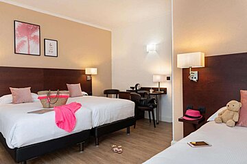 A hotel room with two beds and a desk with a sign on the wall that says i love you