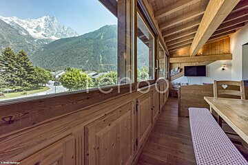 A dining room with a view of the mountains and a table and chairs