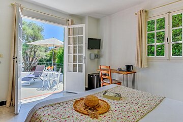 A bedroom with a straw hat and a book on the bed