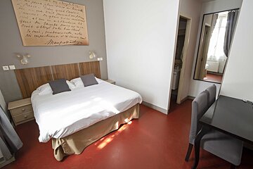 A hotel room with a bed and a sign on the wall that says ' marie antoinette '