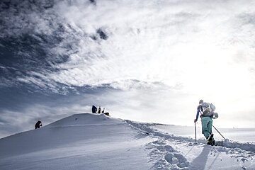 A group of people standing on top of a snow covered mountain