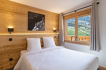 A bedroom with a bed and a picture on the wall