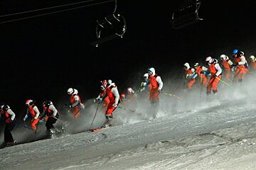 lots of skiers in unison at night