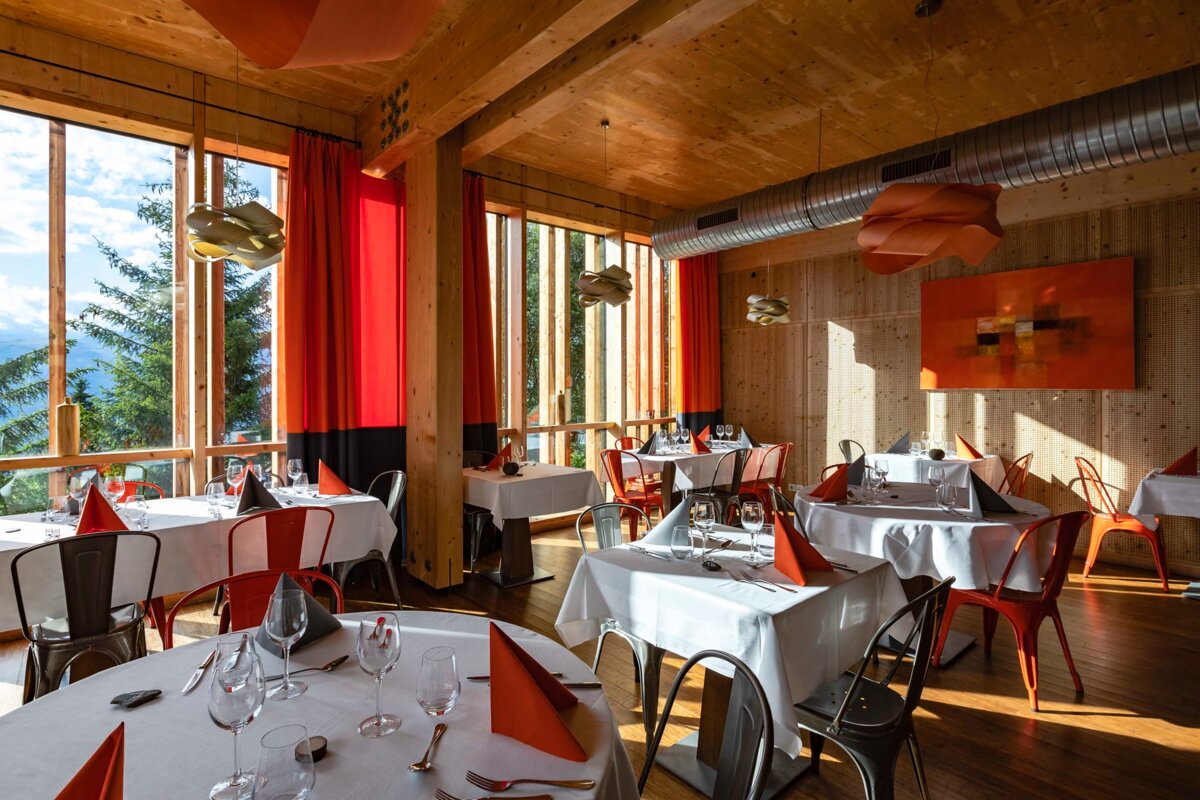 A restaurant with tables and chairs and a painting on the wall