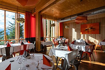 A restaurant with tables and chairs and a painting on the wall