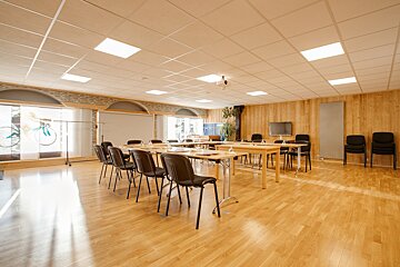 A room with tables and chairs set up for a meeting