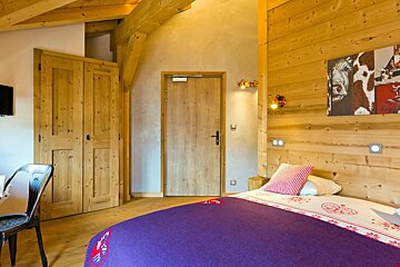 A bedroom with a cow painting on the wall above the bed