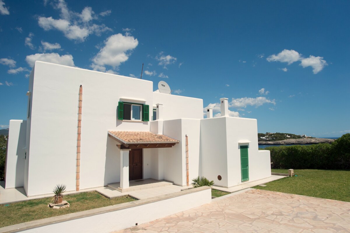 A white house with a satellite dish on top of it