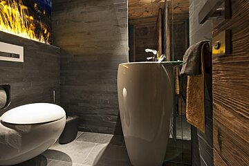 A bathroom with a toilet a sink and a wooden door