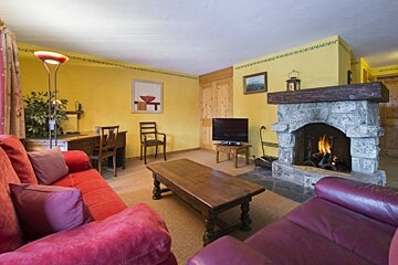 A living room with a fireplace and a red couch