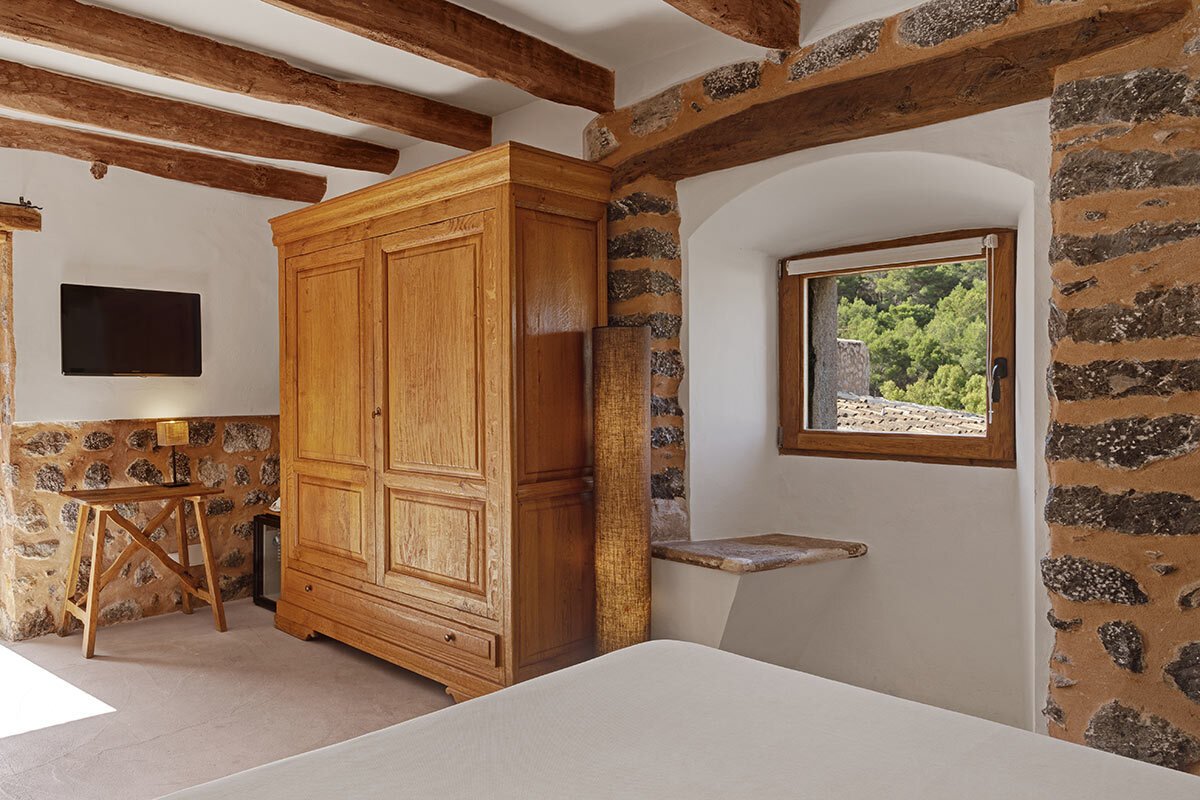 A bedroom with a wooden wardrobe and a window