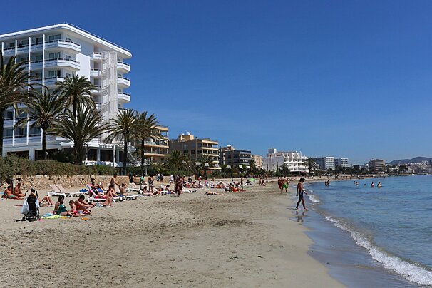A beach scene with a hotel in the background