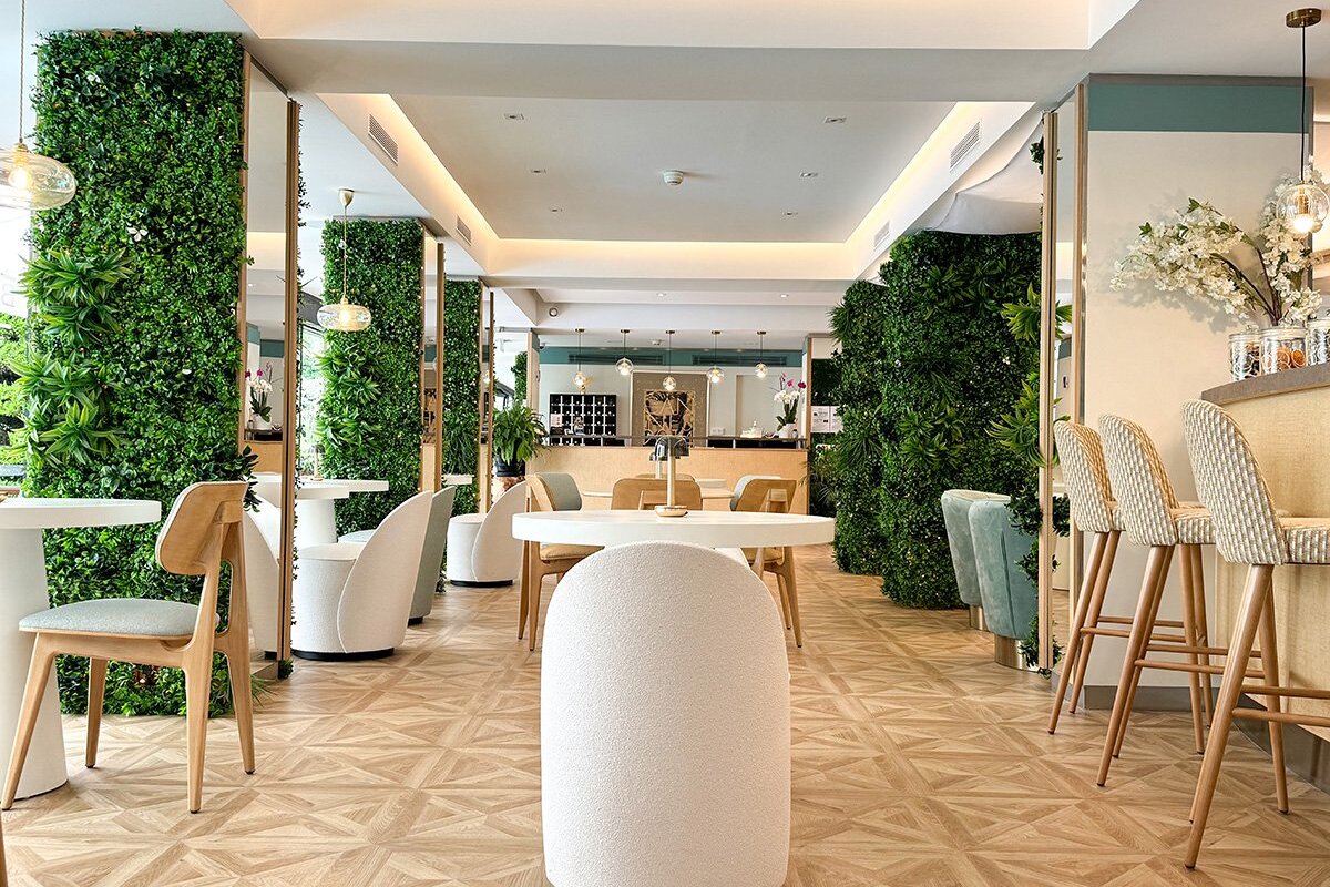 A restaurant with tables and chairs and a green wall