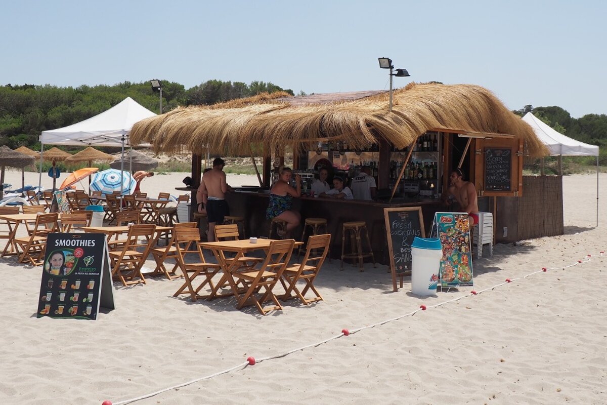 a beach bar with reeds on the roof