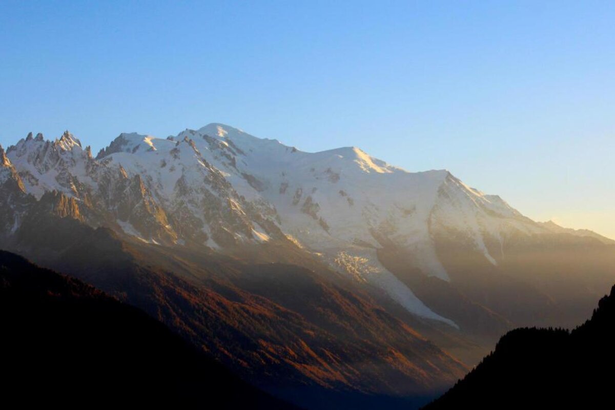 A snowy mountain range with a blue sky in the background