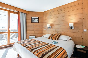 A bedroom with a bed and a picture on the wall