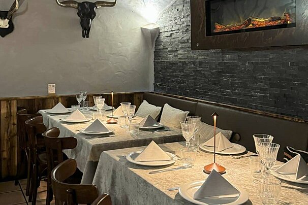 A dining room with a fireplace and a skull on the wall