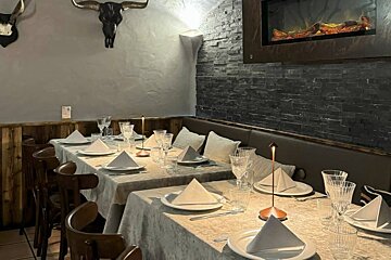 A dining room with a fireplace and a skull on the wall