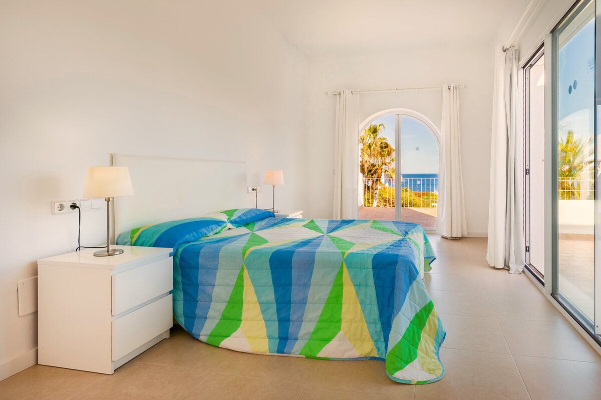A bedroom with a blue and green striped comforter