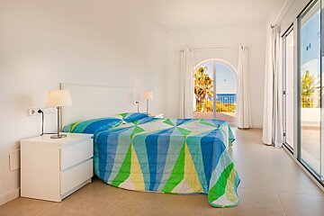 A bedroom with a blue and green striped comforter
