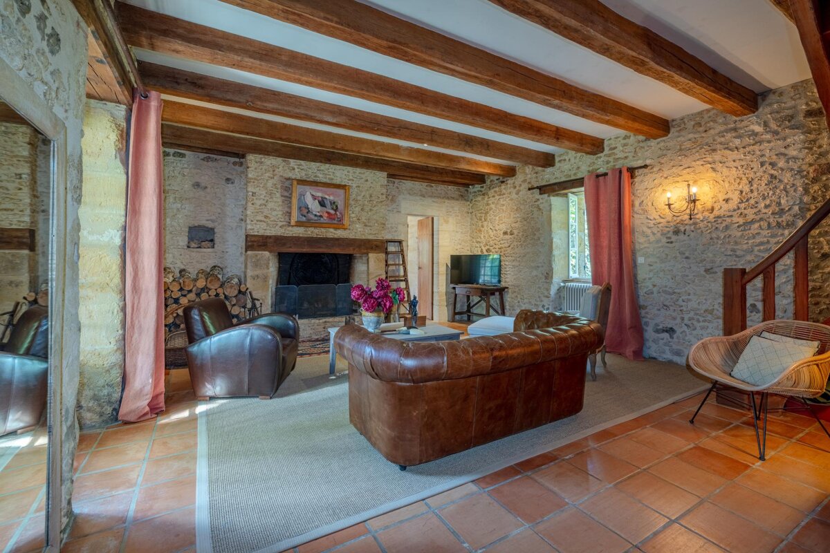 A living room with a couch and chairs and a fireplace