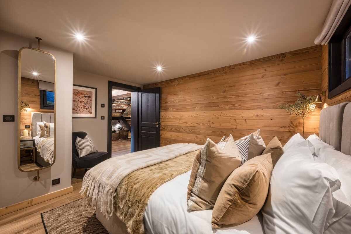 A bedroom with a large bed and a mirror