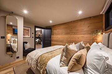 A bedroom with a large bed and a mirror