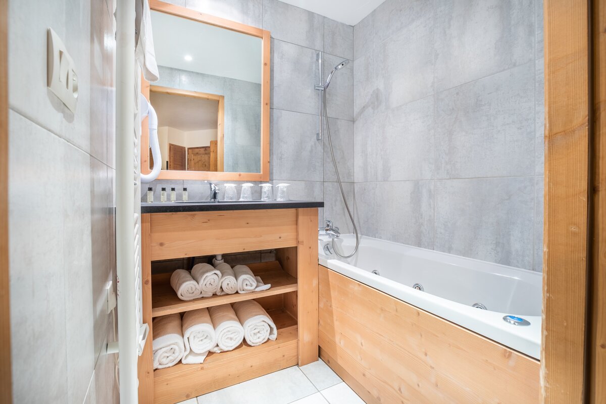 A bathroom with a bathtub a sink and a mirror