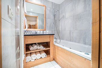 A bathroom with a bathtub a sink and a mirror