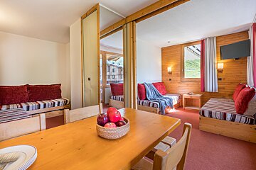 A wooden table with a bowl of apples on it