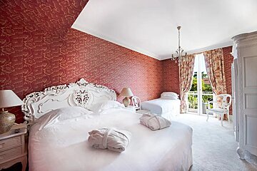 A bedroom with two beds and a chandelier