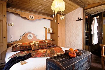 A bedroom with a bed and a trunk with pumpkins on it