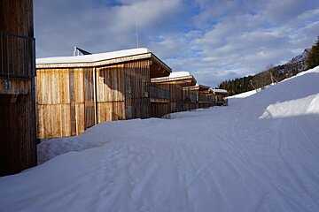 A snowy path leading to a row of wooden houses