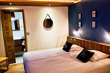 A bedroom with a bed and a mirror on the wall